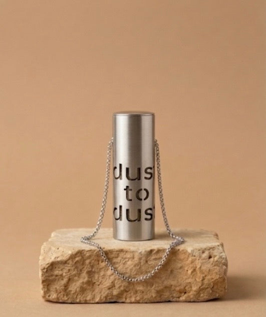 Dust to Dust stainless steel pendant on a chain, resting on Jerusalem stone