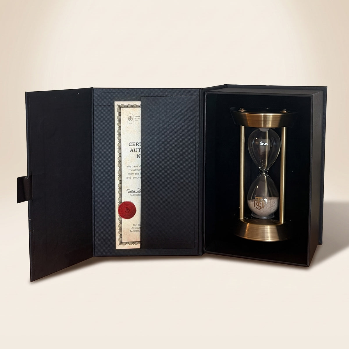 The Temple Mount Hourglass in its open black presentation box beside the numbered Certificate of Authenticity