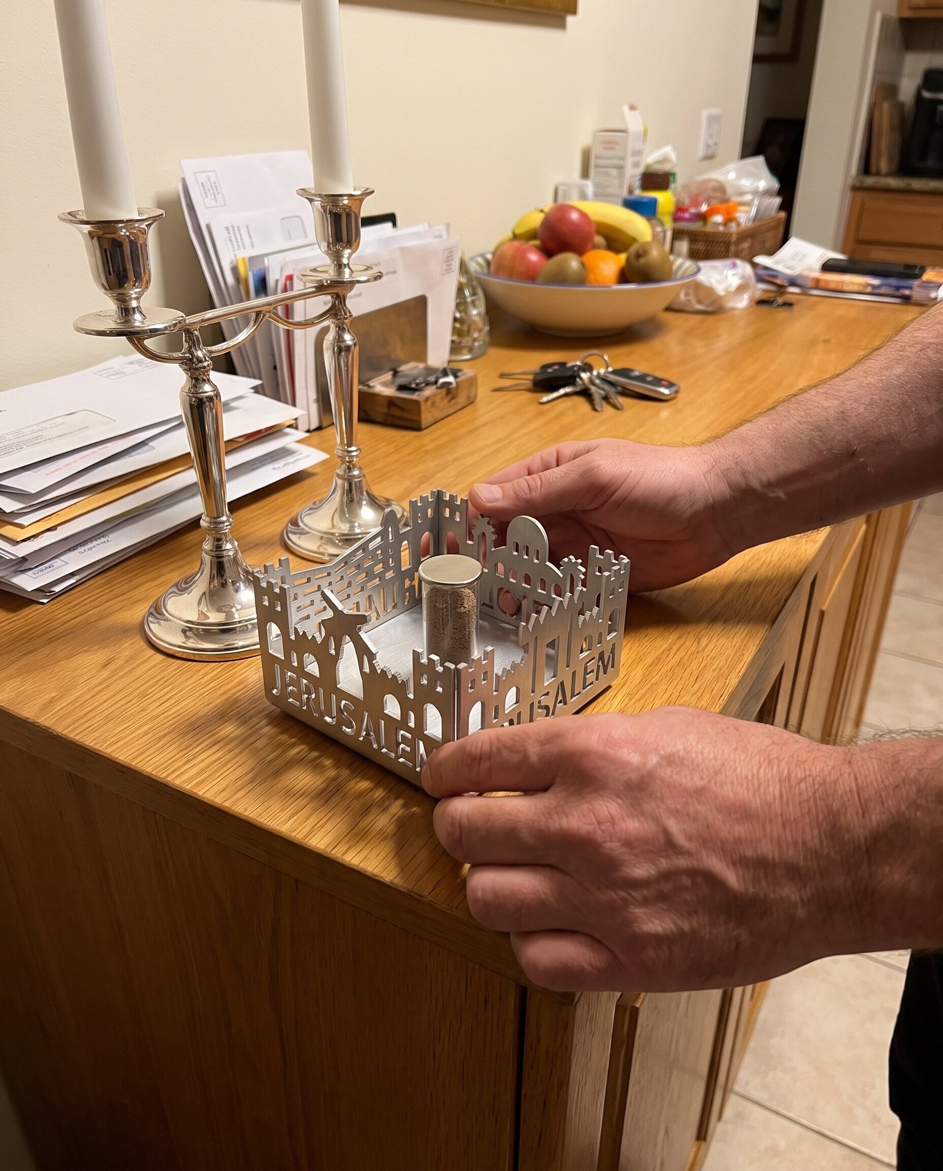 Setting Jerusalem of Gold on a sideboard beside Shabbat candlesticks
