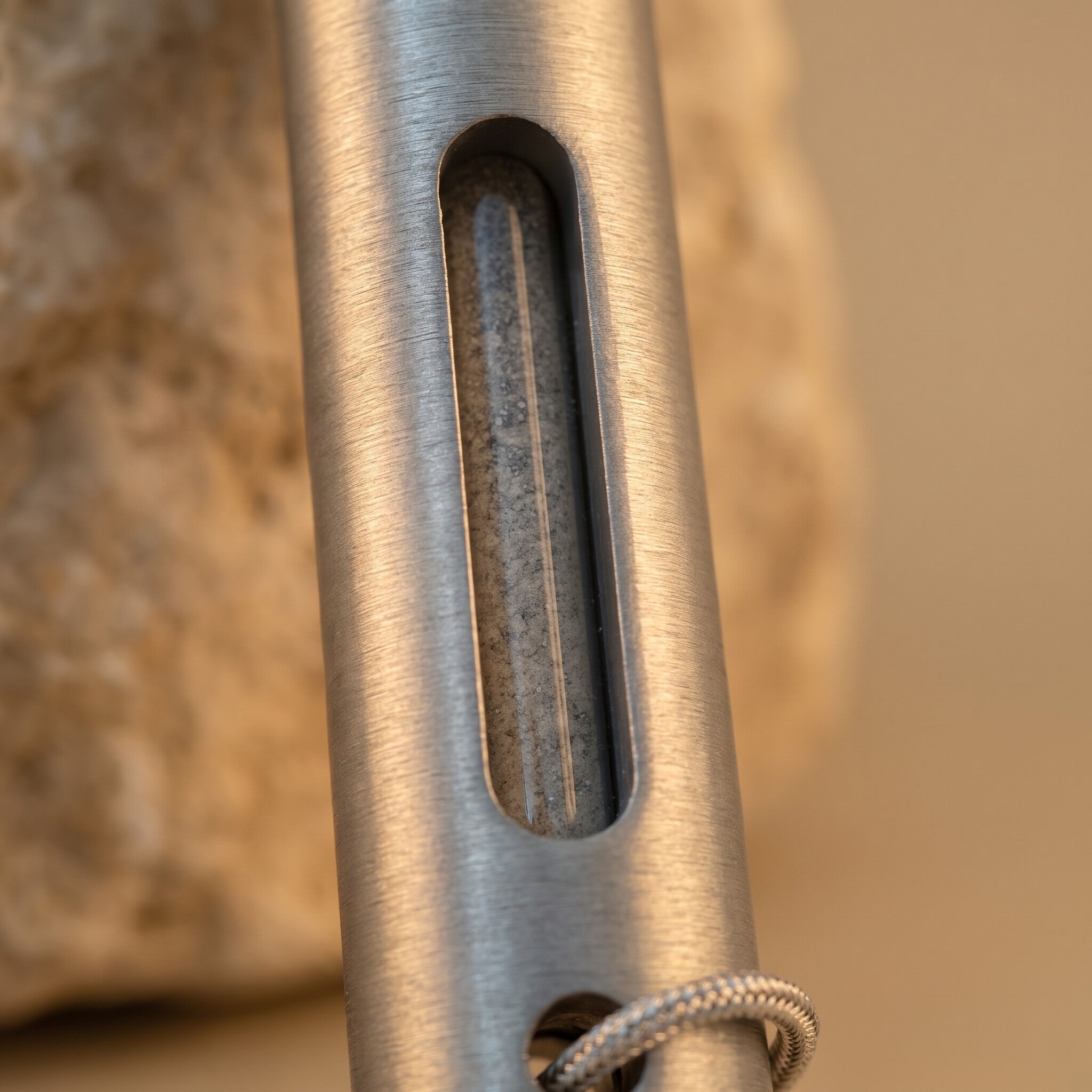 Close view of the sealed capsule of grey Temple Mount soil inside the pointer's window