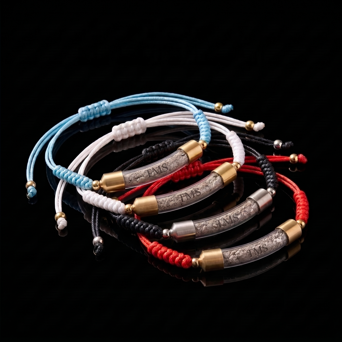Four Covenant Soil Bracelets, blue, white, black and red cords, on black