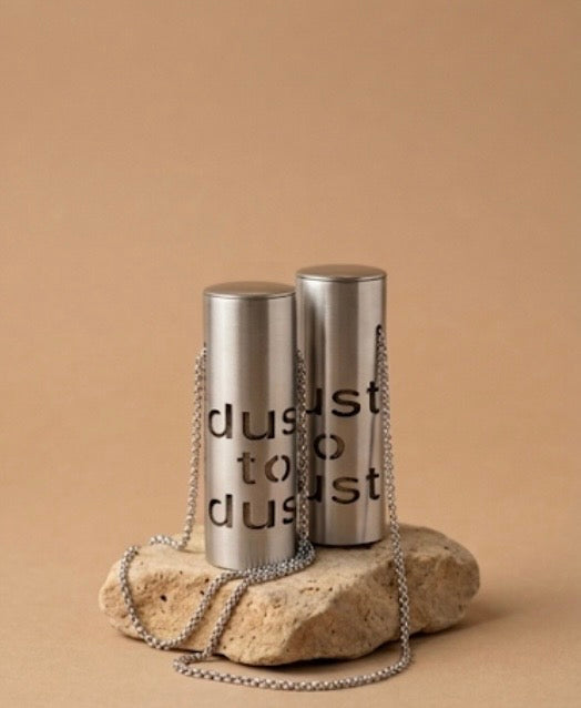 Two Dust to Dust pendants showing the cut lettering from both sides