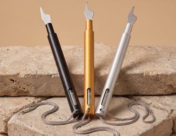 The Hand of the Scroll Torah pointer in black, gold, and silver finishes on Jerusalem limestone